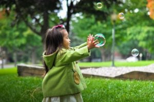Kamali'i blog post image of little girl playing with bubbles